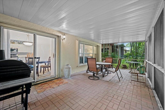 1047 Via Jardin, Riviera Beach, FL 33418 - sunroom / solarium featuring outdoor dining area, brick patterned floors, and a textured wall