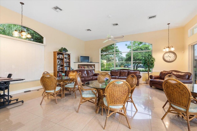 1047 Via Jardin, Riviera Beach, FL 33418 - dining area featuring a chandelier, light tile patterned flooring, a ceiling fan, and a towering ceiling