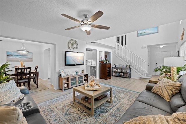 1047 Via Jardin, Riviera Beach, FL 33418 - living area featuring stairway, light wood-style floors, a ceiling fan, and a textured ceiling
