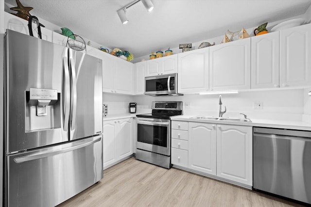 1047 Via Jardin, Riviera Beach, FL 33418 - kitchen with appliances with stainless steel finishes, white cabinetry, light countertops, and light wood-style flooring