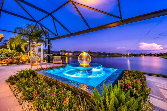 10948 SW Ivory Springs Ln, Port Saint Lucie, FL 34987 - pool at dusk featuring a water view, glass enclosure, and a patio