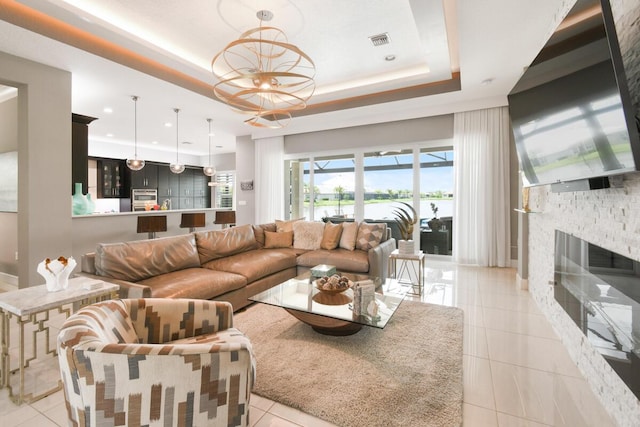 10948 SW Ivory Springs Ln, Port Saint Lucie, FL 34987 - living area with a raised ceiling, a stone fireplace, light tile patterned flooring, and recessed lighting