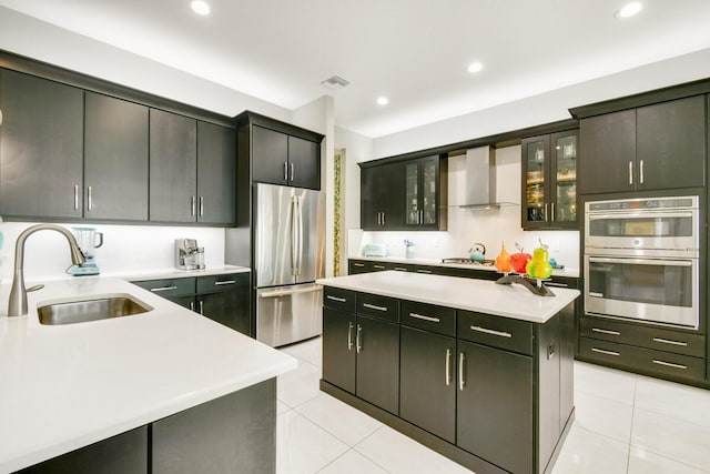 10948 SW Ivory Springs Ln, Port Saint Lucie, FL 34987 - kitchen featuring appliances with stainless steel finishes, wall chimney range hood, light countertops, a kitchen island, and light tile patterned flooring