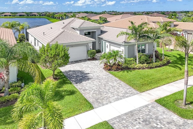 10948 SW Ivory Springs Ln, Port Saint Lucie, FL 34987 - view of front of property with an attached garage, stucco siding, a tiled roof, decorative driveway, and a front lawn