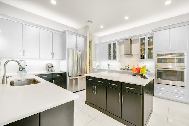 10948 SW Ivory Springs Ln, Port Saint Lucie, FL 34987 - kitchen featuring appliances with stainless steel finishes, wall chimney range hood, light countertops, a kitchen island, and light tile patterned floors