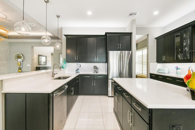 10948 SW Ivory Springs Ln, Port Saint Lucie, FL 34987 - kitchen featuring stainless steel appliances, light countertops, pendant lighting, light tile patterned flooring, and a peninsula