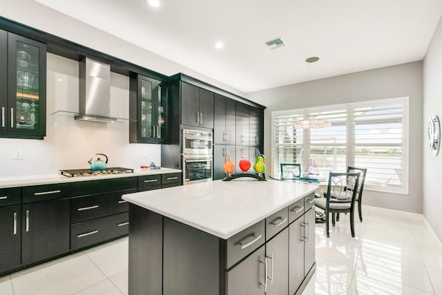10948 SW Ivory Springs Ln, Port Saint Lucie, FL 34987 - kitchen with light countertops, stainless steel appliances, wall chimney range hood, light tile patterned flooring, and hanging light fixtures