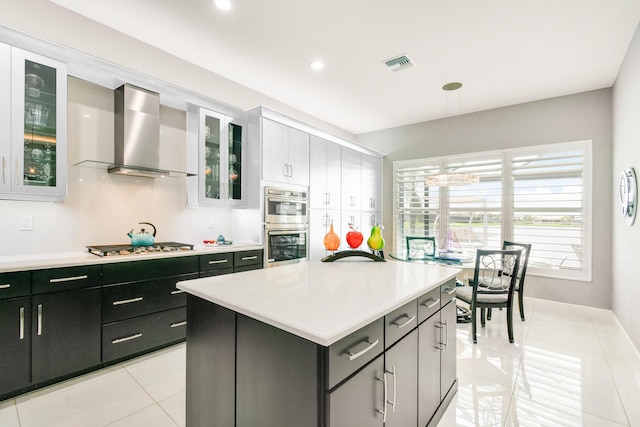 10948 SW Ivory Springs Ln, Port Saint Lucie, FL 34987 - kitchen with wall chimney range hood, light countertops, stainless steel appliances, light tile patterned floors, and hanging light fixtures
