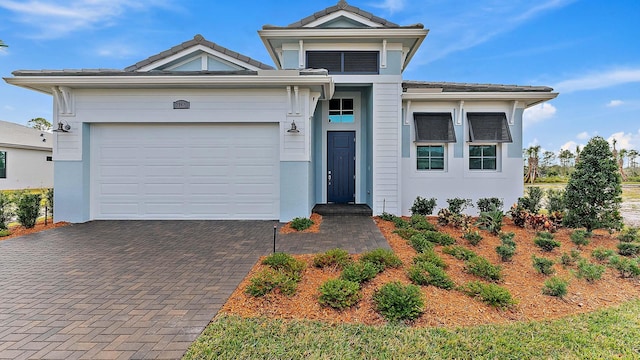 2165 SE Mosaic Blvd, Port Saint Lucie, FL 34984 - view of front facade with decorative driveway, an attached garage, stucco siding, and a tiled roof