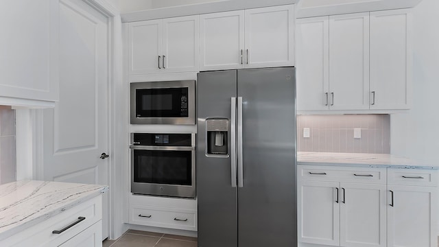 2165 SE Mosaic Blvd, Port Saint Lucie, FL 34984 - kitchen with appliances with stainless steel finishes, white cabinets, and light stone countertops