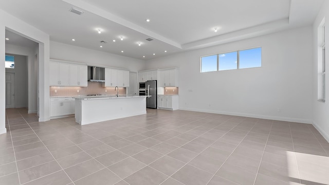 2165 SE Mosaic Blvd, Port Saint Lucie, FL 34984 - kitchen featuring wall chimney exhaust hood, stainless steel appliances, open floor plan, decorative backsplash, and light tile patterned floors