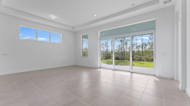 2165 SE Mosaic Blvd, Port Saint Lucie, FL 34984 - empty room featuring light tile patterned floors, recessed lighting, and a raised ceiling