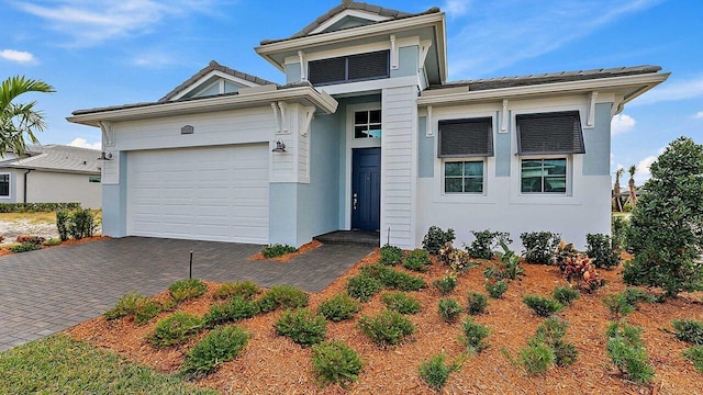 2165 SE Mosaic Blvd, Port Saint Lucie, FL 34984 - view of front of home with an attached garage, decorative driveway, and stucco siding