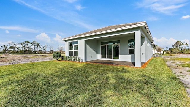 2165 SE Mosaic Blvd, Port Saint Lucie, FL 34984 - back of property with stucco siding, a yard, and a patio area