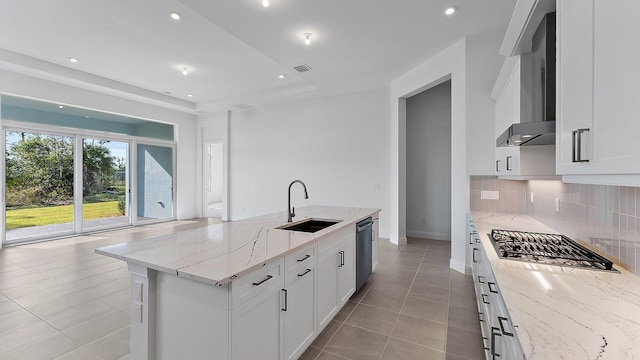 2165 SE Mosaic Blvd, Port Saint Lucie, FL 34984 - kitchen with wall chimney exhaust hood, appliances with stainless steel finishes, backsplash, light tile patterned floors, and white cabinetry