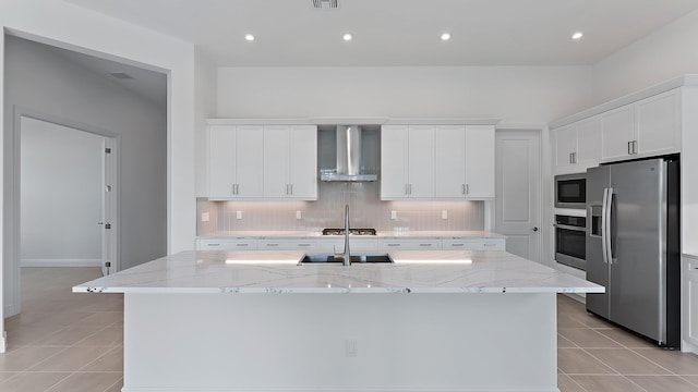 2165 SE Mosaic Blvd, Port Saint Lucie, FL 34984 - kitchen with stainless steel appliances, wall chimney range hood, backsplash, a center island with sink, and light tile patterned floors
