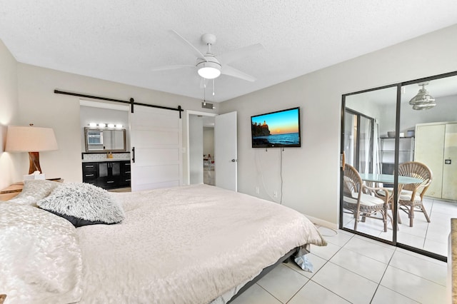 15451 Pembridge Dr Unit 207, Delray Beach, FL 33484 - bedroom featuring a barn door, light tile patterned flooring, a textured ceiling, and a ceiling fan