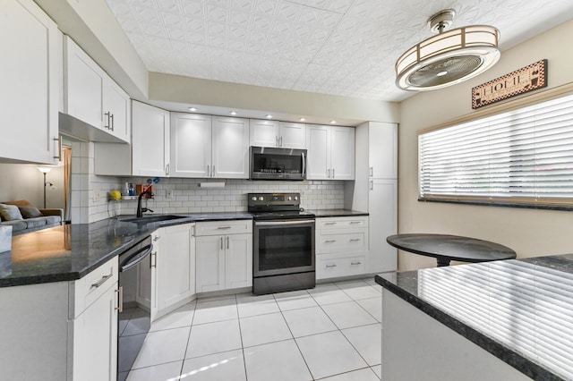 15451 Pembridge Dr Unit 207, Delray Beach, FL 33484 - kitchen featuring electric range, stainless steel microwave, dishwasher, decorative backsplash, and light tile patterned floors