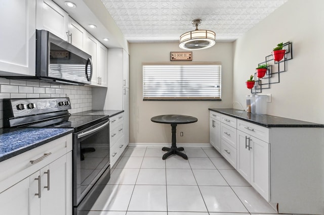 15451 Pembridge Dr Unit 207, Delray Beach, FL 33484 - kitchen with stainless steel appliances, tasteful backsplash, white cabinets, light tile patterned flooring, and pendant lighting