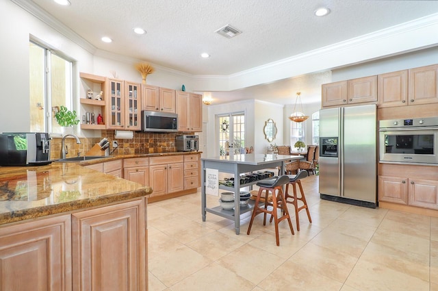 15687 83rd Way N, Palm Beach Gardens, FL 33418 - kitchen featuring stainless steel appliances, light brown cabinetry, decorative backsplash, crown molding, and a textured ceiling