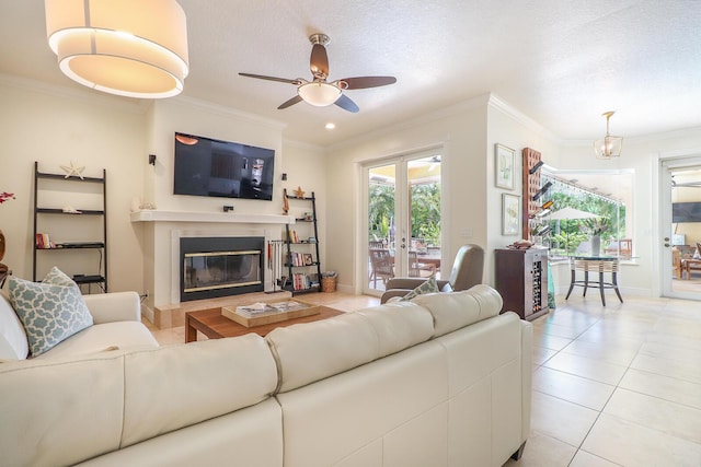 15687 83rd Way N, Palm Beach Gardens, FL 33418 - living room with ceiling fan, a glass covered fireplace, ornamental molding, light tile patterned flooring, and french doors