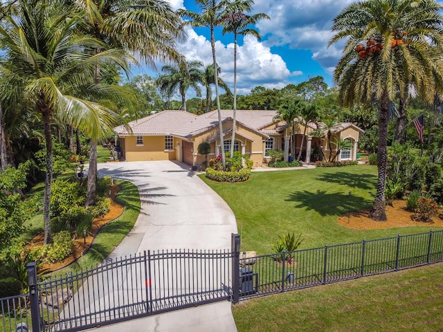 15687 83rd Way N, Palm Beach Gardens, FL 33418 - mediterranean / spanish house with driveway, a tile roof, stucco siding, a fenced front yard, and an attached garage