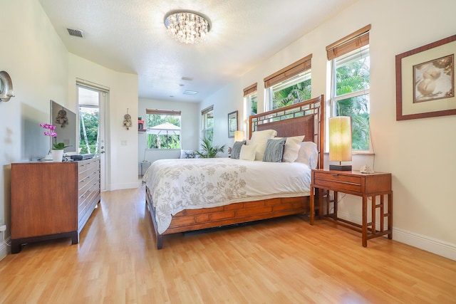 15687 83rd Way N, Palm Beach Gardens, FL 33418 - bedroom with light wood finished floors, multiple windows, and a chandelier