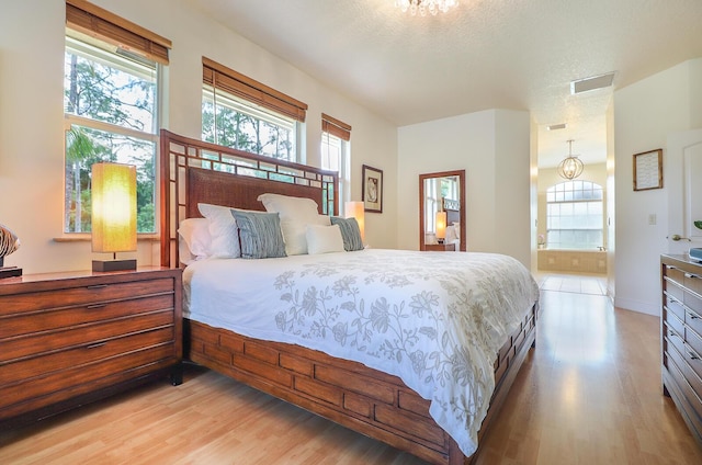 15687 83rd Way N, Palm Beach Gardens, FL 33418 - bedroom featuring light wood finished floors, multiple windows, and connected bathroom