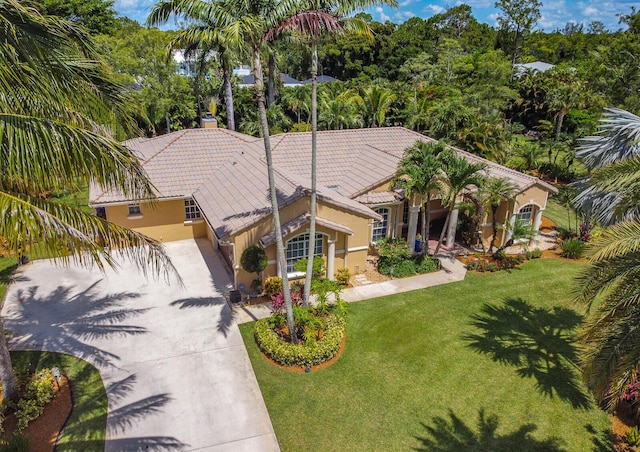 15687 83rd Way N, Palm Beach Gardens, FL 33418 - mediterranean / spanish home featuring a tile roof, stucco siding, driveway, and a front yard