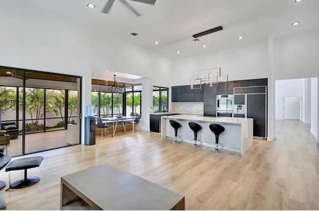 2299 NW 55th St, Boca Raton, FL 33496 - unfurnished living room with a high ceiling, light wood-type flooring, a ceiling fan, and recessed lighting