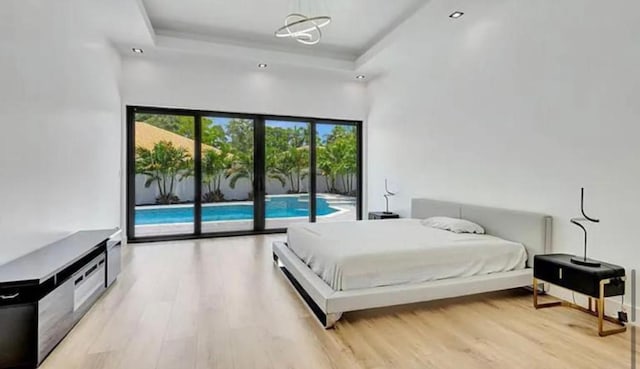 2299 NW 55th St, Boca Raton, FL 33496 - bedroom featuring access to exterior, light wood-style floors, and a tray ceiling