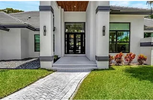 2299 NW 55th St, Boca Raton, FL 33496 - entrance to property featuring stucco siding and a yard