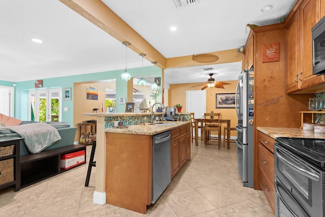 1098 SW 2nd St, Boca Raton, FL 33486 - kitchen featuring stainless steel appliances, a breakfast bar, brown cabinetry, a ceiling fan, and recessed lighting