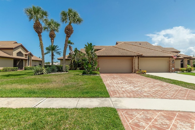 8057 Cassia Dr, Boynton Beach, FL 33472 - view of front facade with a tiled roof, a garage, a front lawn, driveway, and stucco siding
