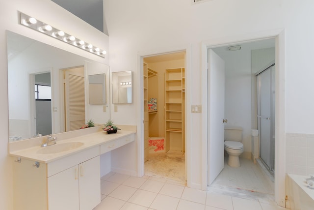 8057 Cassia Dr, Boynton Beach, FL 33472 - full bathroom with vanity, a walk in closet, a shower stall, a garden tub, and tile patterned floors