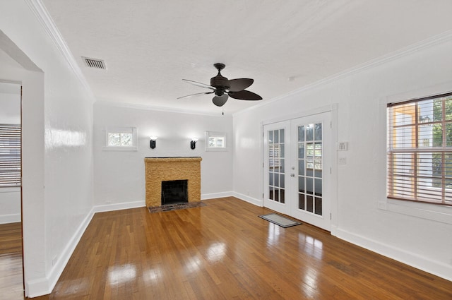 511 S K St, Lake Worth Beach, FL 33460 - unfurnished living room featuring hardwood / wood-style flooring, french doors, ornamental molding, a ceiling fan, and a tile fireplace
