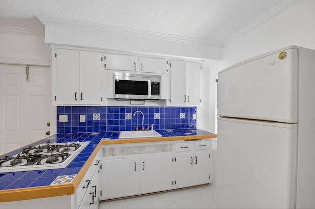 511 S K St, Lake Worth Beach, FL 33460 - kitchen featuring white appliances, ornamental molding, white cabinets, backsplash, and tile counters