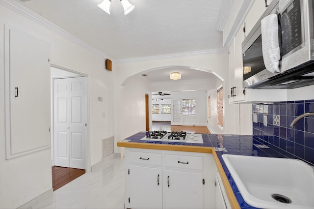 511 S K St, Lake Worth Beach, FL 33460 - kitchen with stainless steel microwave, white gas cooktop, arched walkways, a ceiling fan, and crown molding