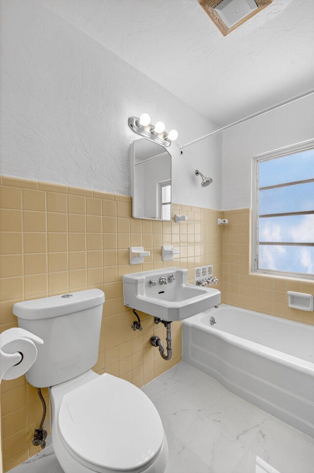 511 S K St, Lake Worth Beach, FL 33460 - bathroom with tile walls, shower / tub combination, and wainscoting