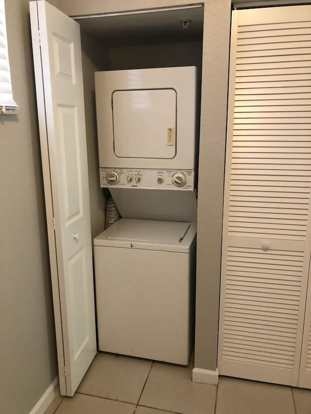 1991 Marsh Harbor Dr, Riviera Beach, FL 33404 - laundry room with stacked washer / drying machine and light tile patterned floors