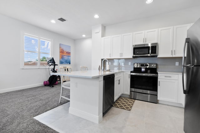 13313 Machiavelli Way, Palm Beach Gardens, FL 33418 - kitchen featuring stainless steel appliances, a peninsula, light carpet, white cabinets, and backsplash
