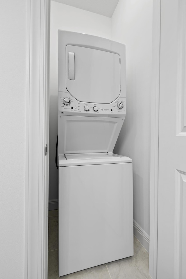 13313 Machiavelli Way, Palm Beach Gardens, FL 33418 - washroom featuring stacked washing machine and dryer and light tile patterned flooring