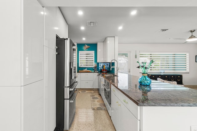 301 Linda Ln, West Palm Beach, FL 33405 - kitchen featuring freestanding refrigerator, white cabinets, a peninsula, dark aggregate flooring, and recessed lighting
