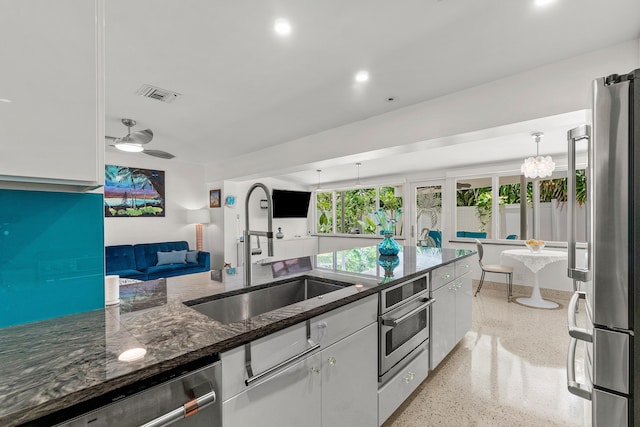 301 Linda Ln, West Palm Beach, FL 33405 - kitchen featuring appliances with stainless steel finishes, dark aggregate flooring, white cabinetry, dark stone countertops, and open floor plan
