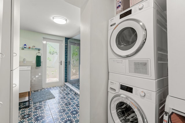 301 Linda Ln, West Palm Beach, FL 33405 - laundry area with stacked washer / dryer and tile patterned floors