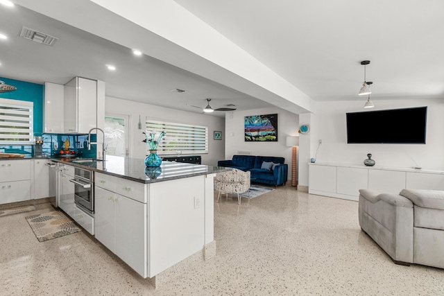 301 Linda Ln, West Palm Beach, FL 33405 - kitchen with open floor plan, white cabinets, dark speckled floor, a peninsula, and recessed lighting