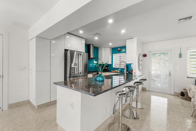 301 Linda Ln, West Palm Beach, FL 33405 - kitchen featuring high end refrigerator, dark speckled floor, modern cabinets, a kitchen breakfast bar, and white cabinetry