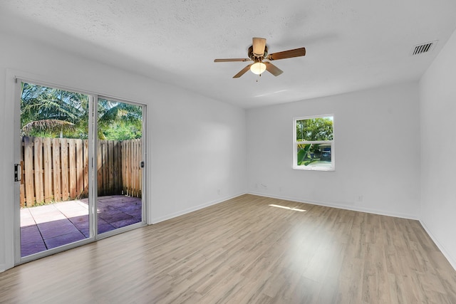 5801 SE Cable Dr, Stuart, FL 34997 - empty room featuring wood finished floors, healthy amount of natural light, and a ceiling fan