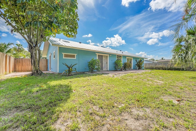 5801 SE Cable Dr, Stuart, FL 34997 - back of property with a fenced backyard, a metal roof, and a patio