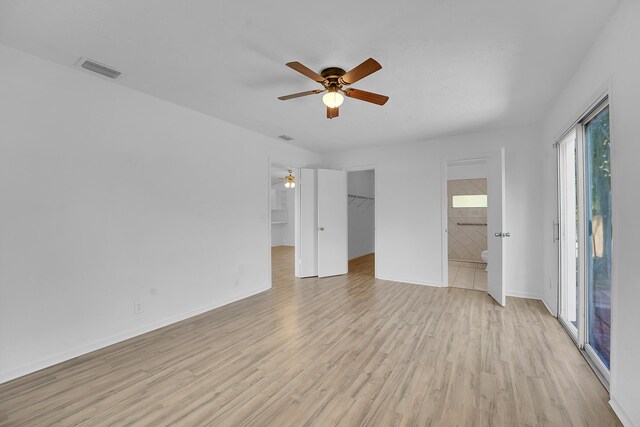 5801 SE Cable Dr, Stuart, FL 34997 - unfurnished bedroom with light wood finished floors, access to exterior, connected bathroom, a spacious closet, and a ceiling fan